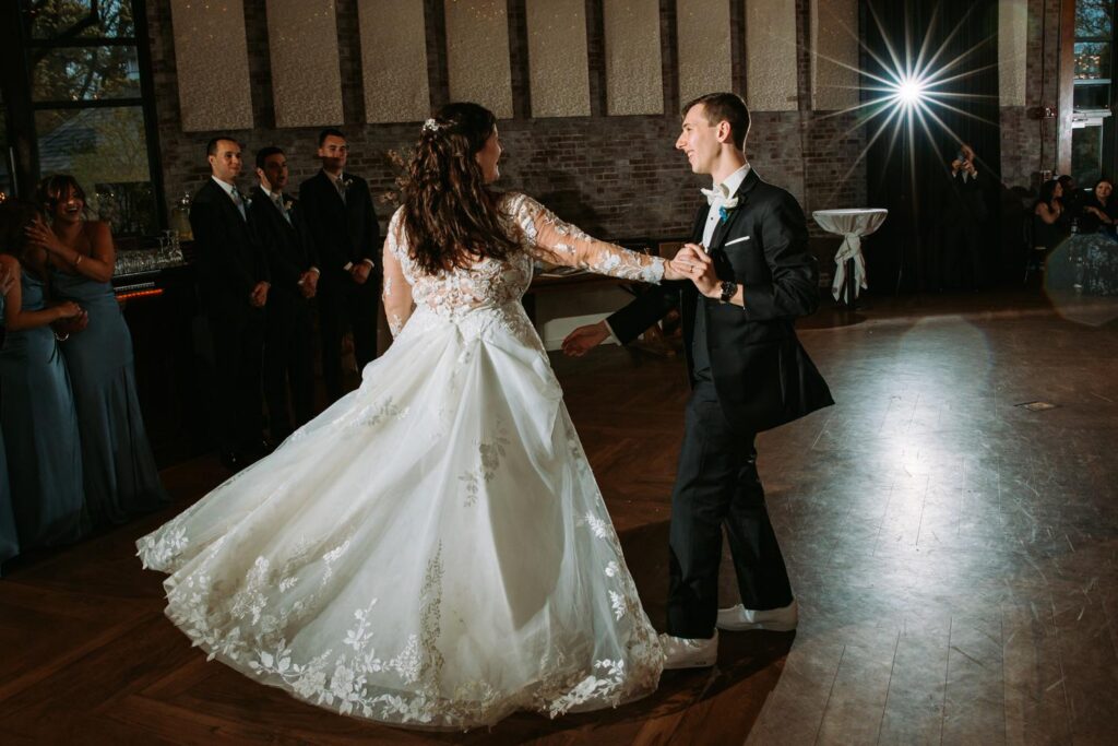 Bride and groom first dance, bride spinning in lace gown, Pond House wedding reception