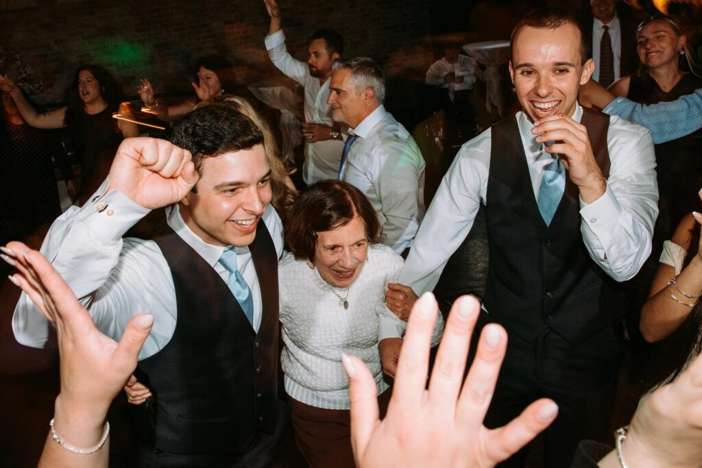 Groomsman celebrating on the dance floor, candid wedding reception moment

