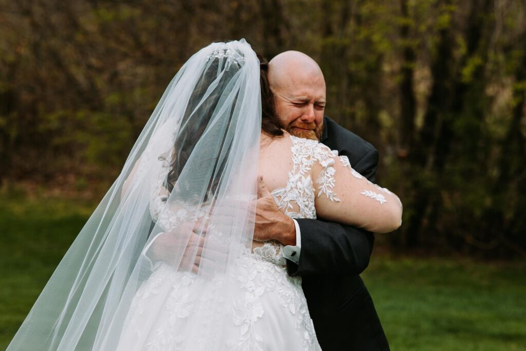 Father of the bride emotional first look seeing his daughter in her wedding dress outdoors