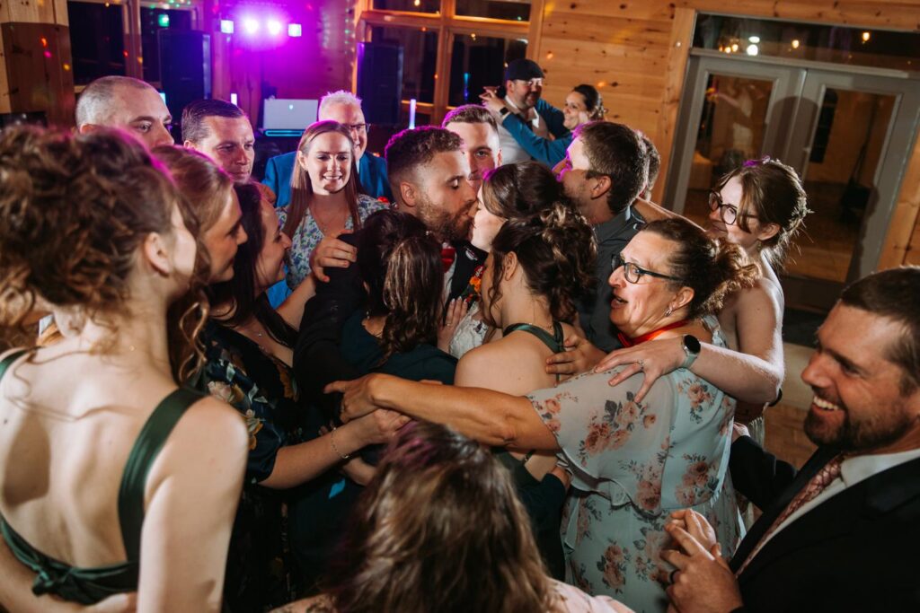 Packed dance floor at Bluebird Farm with colorful DJ lights, full crowd celebrating late into the night