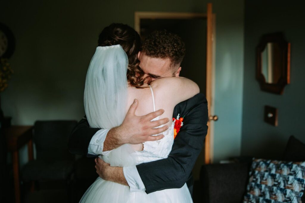 Bride and groom sharing a long emotional hug immediately after the ceremony