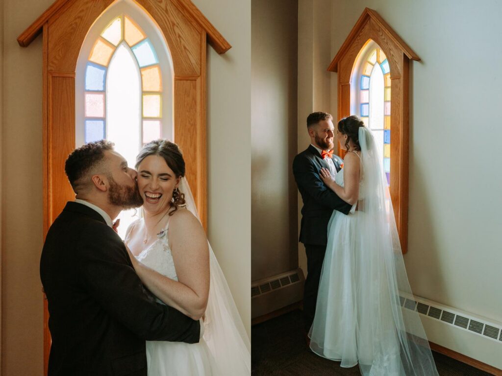 Bride and groom kissing inside the church near a stained glass window, warm and intimate portrait
