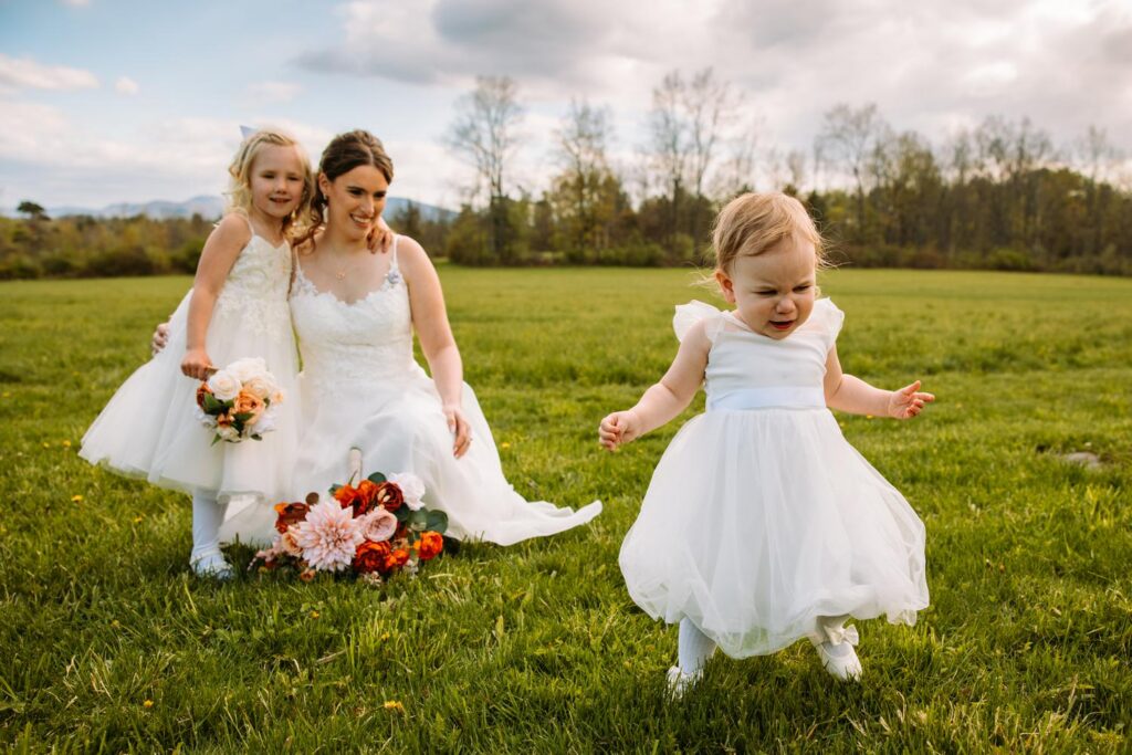 Flower girl running away from the bride in the open field, pure candid joy, Bluebird Farm portraits