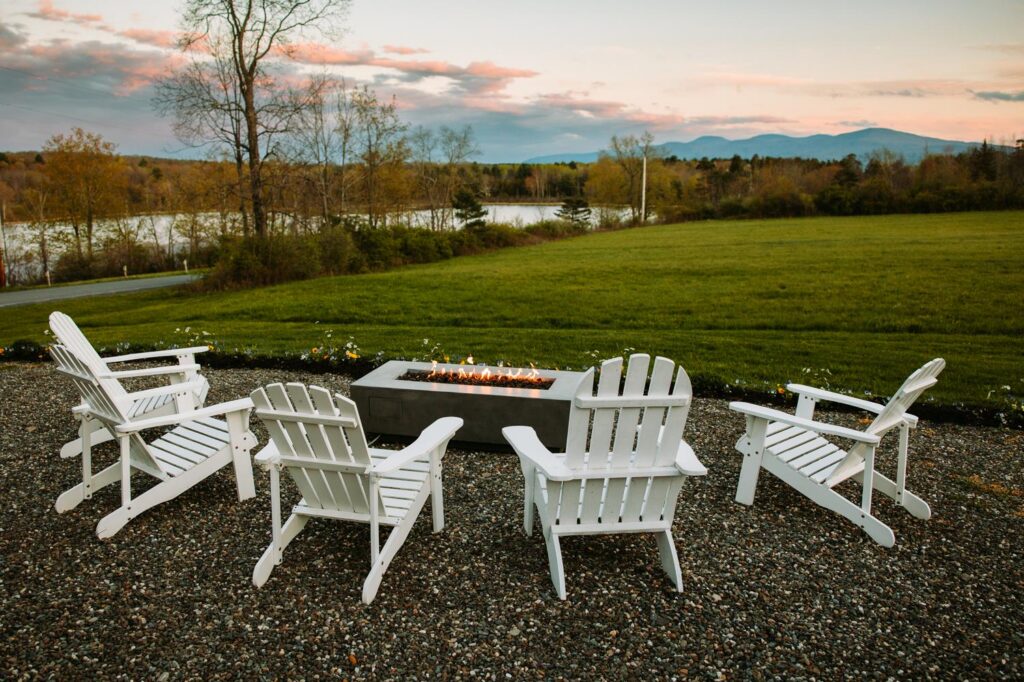 Bluebird Farm patio at dusk with Adirondack chairs, fire pit, and soft Catskill Mountain evening light