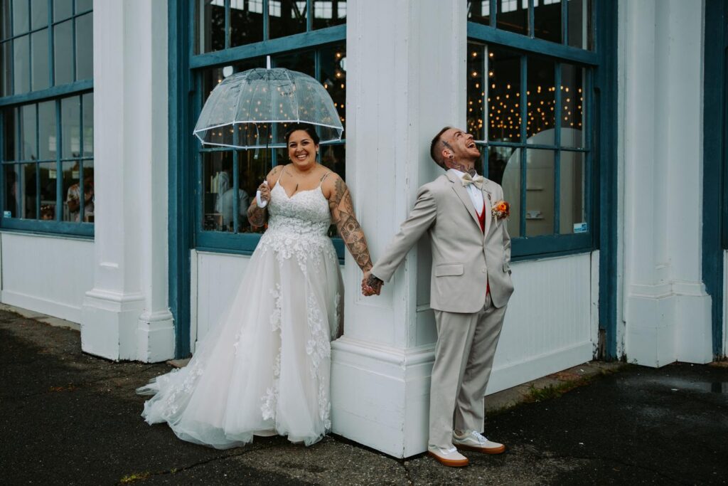 Nicole and Sabin holding hands in first touch position outside the large blue-framed windows of Lighthouse Point Park Ranger Statio