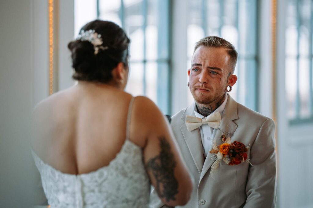 Close up of Sabin with tears running down his face looking at Nicole during the wedding ceremony