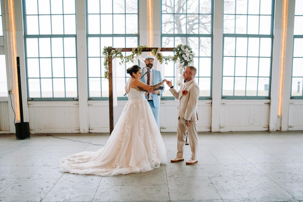 Nicole and Sabin performing their secret handshake right after the first kiss, still standing at the altar, guests watching
